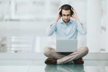 Corporation employee putting on noise canceling headphones to focus on work