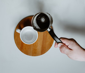 cup of coffee with cezve  on a wooden board