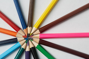 Fototapeta premium Several colored pencils of various shades lie on a white background, macro photography.