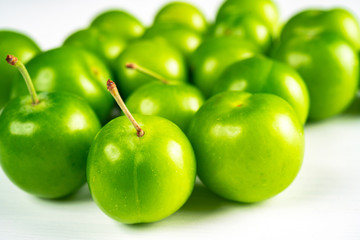 Close-up macro fresh green sour plum. Greengage on white background.