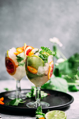 Lemonade with orange, lime, kumquat and mint in a glass