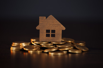 Model of house on stack of coins. Concept of Investment property.