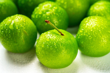 Close-up macro fresh green sour plum. Greengage on white background.