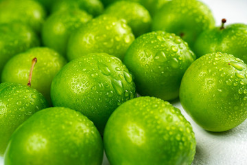 Close-up macro fresh green sour plum. Greengage on white background.