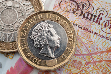 Business and finance, British economy and currency exchange concept with macro close up on one pound and two pounds coins and 10 GBP bank note - obrazy, fototapety, plakaty