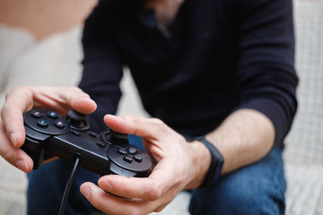 A man plays video games with a joystick in his hands