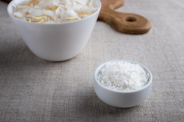 Coconut chips and shavings in a bowl on a cloth tablecloth