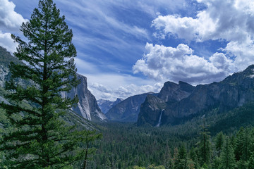 Yosemite National Park view from observation deck on mountains and waterfall in sunny weather blue sky with clouds