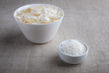 Coconut chips and shavings in a bowl on a cloth tablecloth