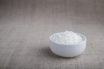Coconut flakes in a bowl on the table