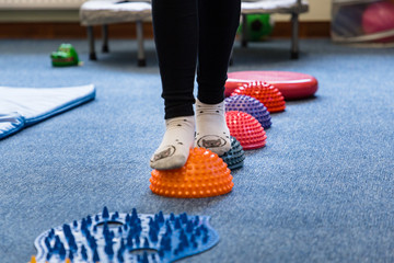 
Pediatric Sensory Integration Therapy - a child walking on a sensory mat and pillows (close-up picture)