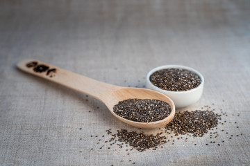 Chia seed in a bowl and on a wooden spoon on the table