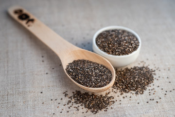 Chia seed in a bowl and on a wooden spoon on the table