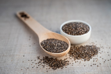 Chia seed in a bowl and on a wooden spoon on the table