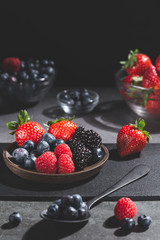 Mixed berries on dark background. Vertical format.