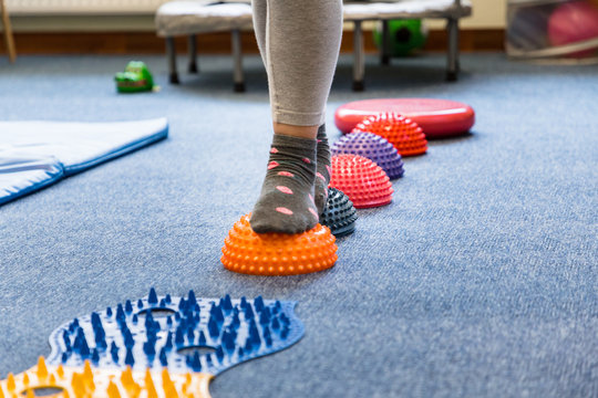 
Pediatric Sensory Integration Therapy - a child walking on a sensory mat and pillows (close-up picture)