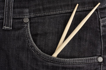 Сhopstick lies in black jeans pocket.