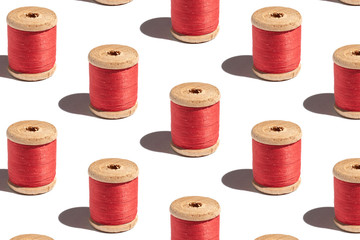 Pattern of spool of red thread on a white background