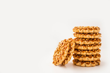 Sweet biscuits with a sprinkling of walnuts on a white background