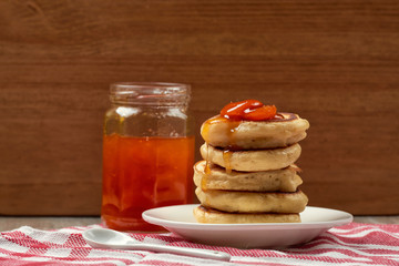 pancakes with apricot jam on a wooden background. Food for Breakfast in the morning. recipe for pancakes. selective focus and copy space. home cooking recipe