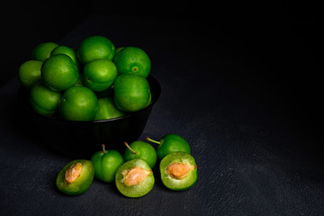 close-up macro fresh green sour plum. Greengage on dark background.
