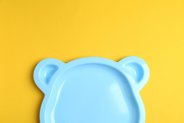 Cute animal shaped plate on yellow background, top view. Serving baby food