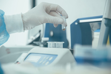 Transparent liquid in micro tube in hand of lab technician