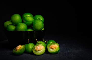 close-up macro fresh green sour plum. Greengage on dark background