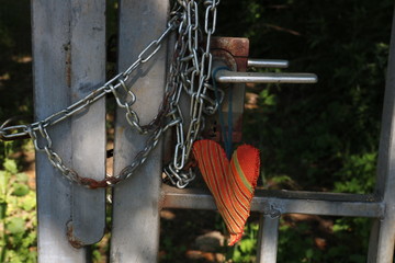 Symbol für mit Herz ein Tor öffnen / Kette und Schloss am Tor mit Stoffherz © contadora1999