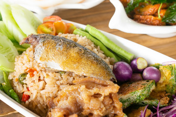 Fried rice mixed shrimp paste sauce with mackerel and omelet mixed Cha-om vegetables in white dish.