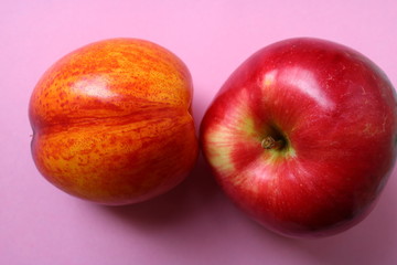 peach, nectarine and Apple on a pink background