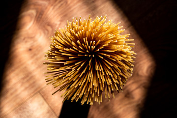 Spiral of Spaghetti on brown wooden floor. 