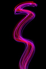 Long exposure photograph of neon colour in an abstract swirl, parallel lines pattern against a black background. Light painting photography.