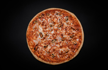 crispy Italian delicious pizza on a black background, pizza ingredients, photo for recipe and menu