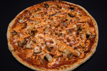 crispy Italian delicious pizza on a black background, pizza ingredients, photo for recipe and menu