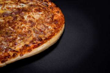 Half pizza on a black background with empty space, top view. Copy space