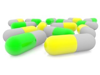 Yellow and green medical capsules on white