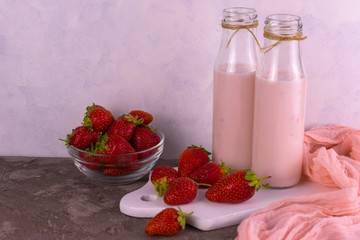 
Two bottles with strawberry smoothie on the table.