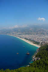 View of bay with old ships and beach coast from mountain in Alanya. Summer holidays in Turkey. Beautiful sea view.                               