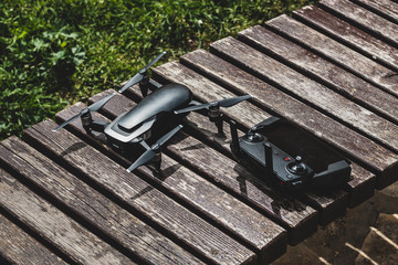 Black drone on the wooden bench during a break from shooting.