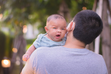 Fototapeta premium Father Holding Newborn Baby Son In Nursery