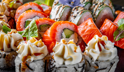 set of sushi roll with salmon, avocado, cream cheese, cucumber, rice, caviar, eel, tuna in plate