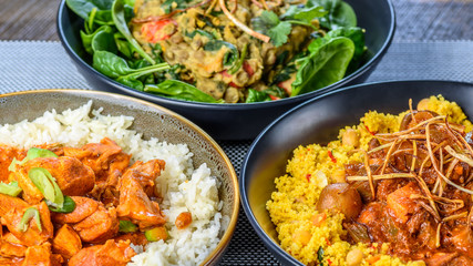 A trio of dishes including Butter Chicken, Vegetarian Dhal and Beef Bourguignon in round bowls