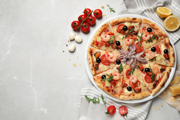 Tasty pizza with seafood and ingredients on light grey marble table, flat lay. Space for text