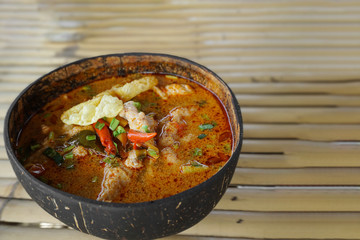 Close up spicy soup with pork in coconut shell