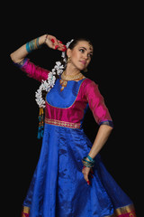 Naklejka premium Girl dancer of Indian dances. A woman in an Indian suit. Portrait on a black background.