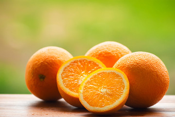 Orange fruits on wooden board, at blurred nature background