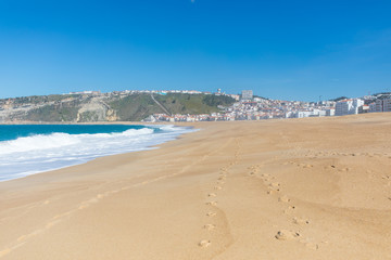 Fototapeta na wymiar Traces on the sand of the beach in Nazare Portugal