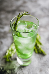 Sweet tequila based green cocktail with tarragon and rosemary. Selective focus. Shallow depth of field.