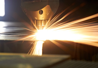 sparks of precision laser cutting of steel sheets on a cnc laser machine during parts manufacturing